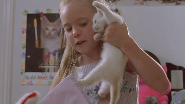 Little Secrets - Lea Danielle Chuchran pulling white kitten Dixie out of her backpack