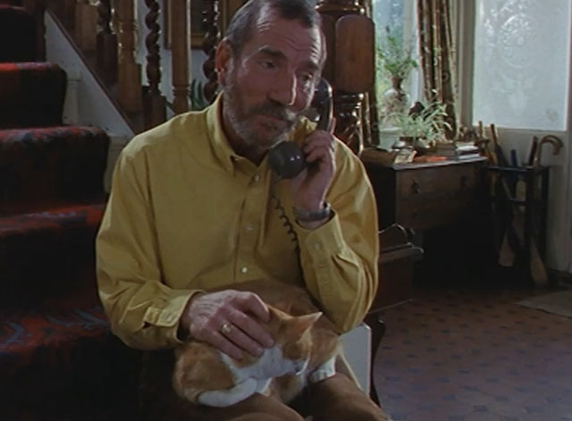 Lost for Words - Deric Peter Postlewaite sitting on stairs with ginger and white tabby cat Whiskey on lap