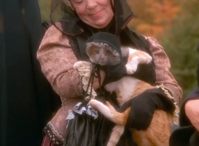 Love at Stake - Aunt Deliverence Norma MacMillan holding ginger and white tabby cat in mourning dress and veil at funeral