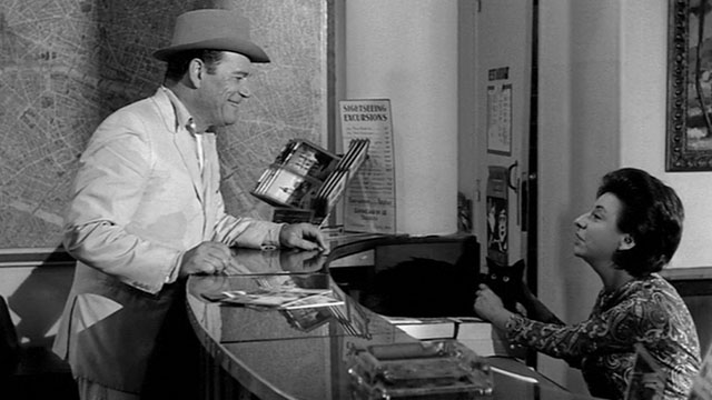 Lucky Jo - Eddie Constantine standing at front desk with Marcelle Ranson-Hervé holding onto black cat Napoleon