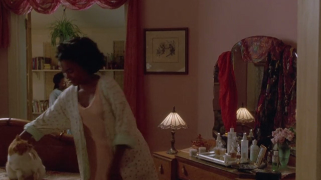 Made in America - Zora Nia Long reaching over to pick up orange and white cat from bed