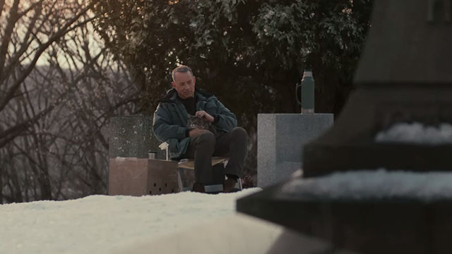 A Man Called Otto - Otto Tom Hanks sitting on chair in cemetery with longhair tabby cat Schmagel on lap