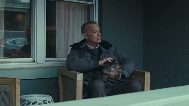 A Man Called Otto - Otto Tom Hanks sitting on porch holding longhair tabby cat Schmagel on lap