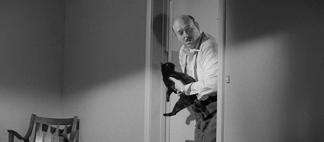 The Man Who Died Twice - black cat held by Hart Gerald Milton in hallway