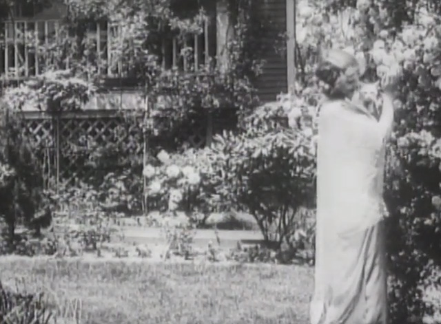 Matrimony's Speed Limit - Marian Swayne walking through garden holding small white cat