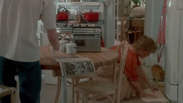 Max Dugan Returns - Nora Marsha Mason wiping up refrigerator spill with orange tabby cat eating from bowl on floor