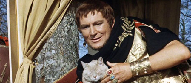 L'ultimo gladiatore - Messalina vs. the Son of Hercules - Caligula Charles Borromel sitting in lectica during battle with cream colored tabby cat