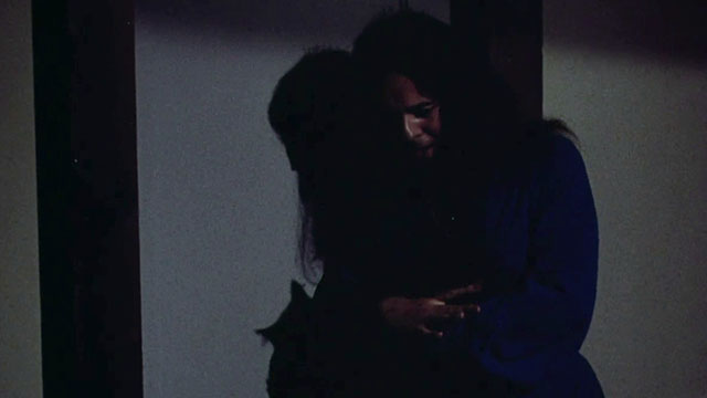 Miss Leslie's Dolls - Miss Leslie Salvador Ugarte holding black cat Tom in dark hallway