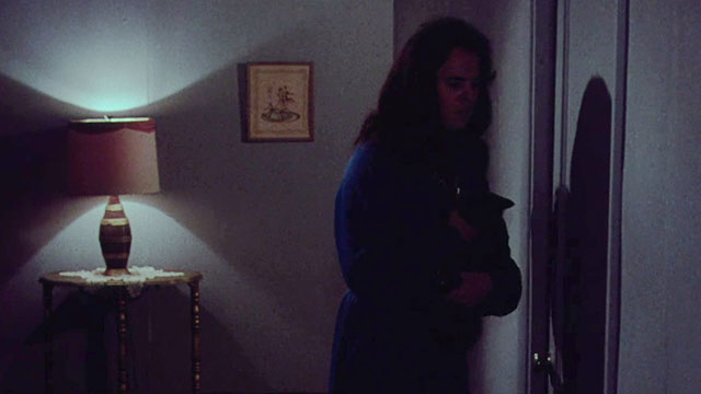 Miss Leslie's Dolls - Miss Leslie Salvador Ugarte holding black cat Tom in dark hallway