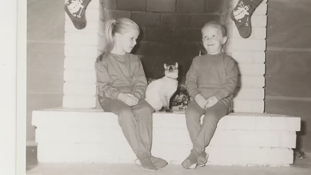 Monogamish - black and white photo of little girls sitting by fireplace with Siamese cat
