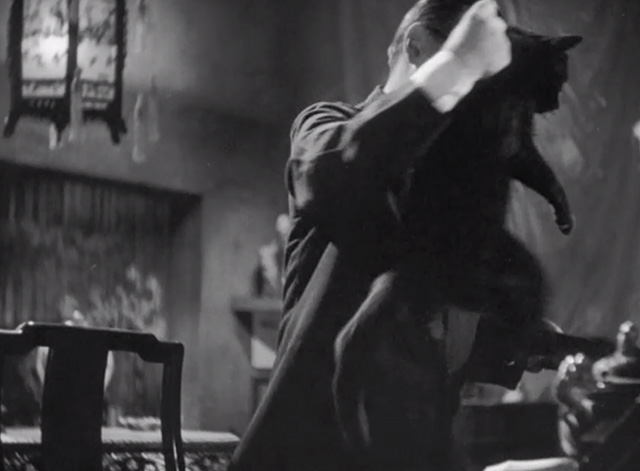 Mr. Moto's Last Warning - black cat Chunkina being picked up by scruff by Mr. Moto Peter Lorre