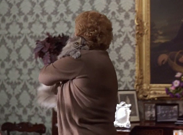 Murder is Easy - Miss Wainfleet Olivia de Havilland picking up longhair Persian diluted calico cat Wonky-Pooh