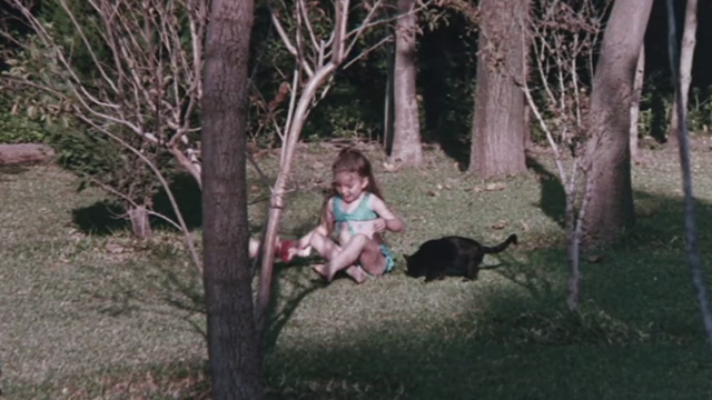 The Night of 1000 Cats - little girl sitting in woods with black cat