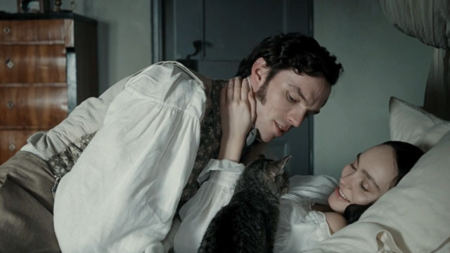 Nosferatu - Ellen Lily-Rose Depp and Thomas Nicholas Hoult on bed with silver tabby cat Greta