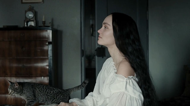 Nosferatu - Ellen Lily-Rose Depp on bed with silver tabby cat Greta