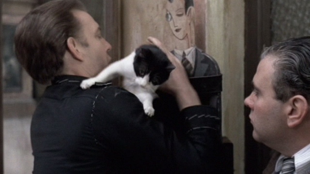 Novecento - 1900 - Attila Donald Sutherland strapping tuxedo cat to tailor shop sign with belt