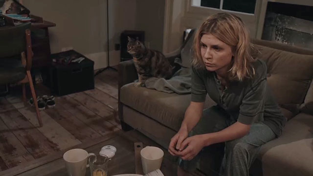 The Ones Below - torbie cat sitting on couch with Kate Clémence Poésy