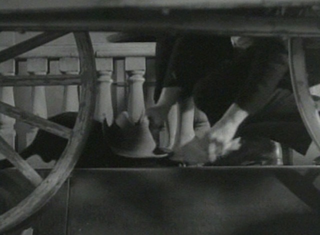 Parachute Jumper - black cat crouched on sidewalk with hat over head as man steals fish