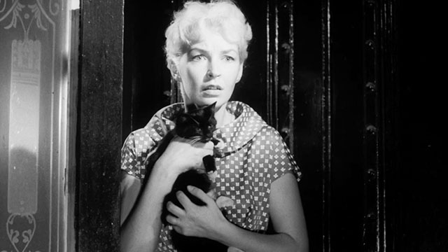 Passport to Shame - Room 43 - Malou Odile Versois holding black and white tuxedo kitten Mignon outside door