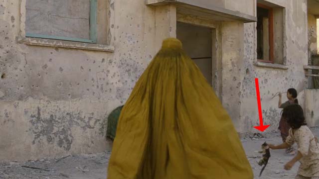 The Patience Stone - little girl carrying kitten by scruff in street