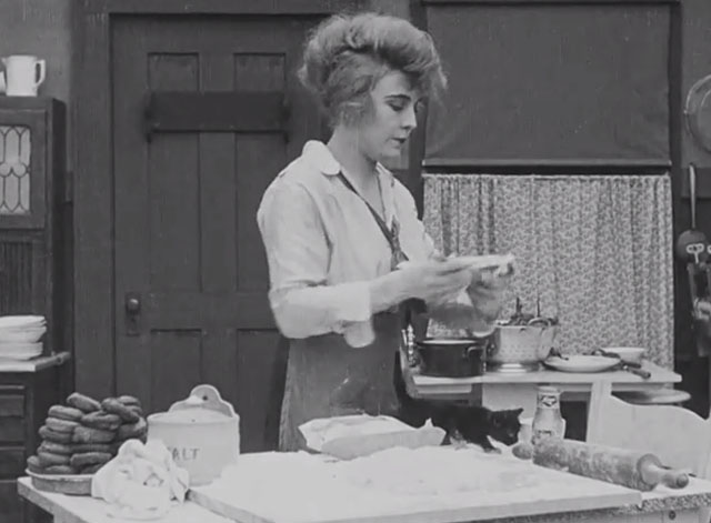 The Pawnshop - black kitten with white paws on kitchen table with Edna Purviance