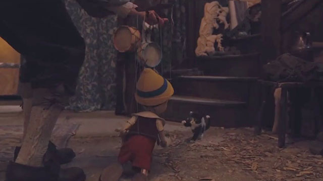 Pinocchio - black and white tuxedo kitten Figaro backed into corner by Geppetto working Pinocchio