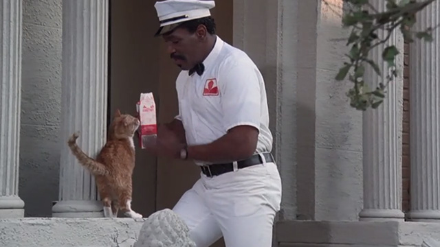 Police Academy 6: City Under Siege - Hightower Bubba Smith dressed as milkman with orange tabby cat on steps