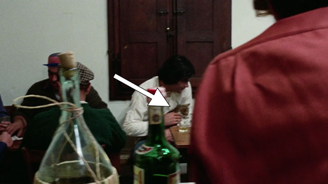 The Police Are Blundering in the Dark - La polizia brancola nel buio - man holding calico tabby cat in bar