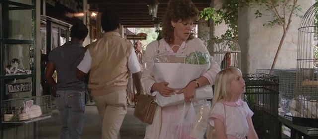 Poltergeist 2 - Carol Anne Heather O'Rourke being led away from kittens in window of pet store by mother JoBeth Williams