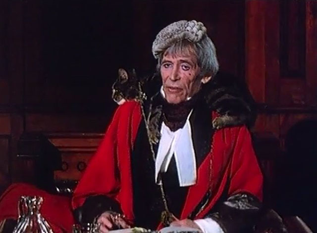 Rebecca's Daughters - Lord Sarn Peter O'Toole on magistrate bench with brown tabby cat Rover over shoulders