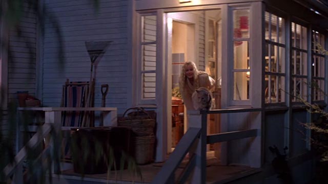 Roxanne - orange cat Grover on railing outside house with Roxanne Daryl Hannah