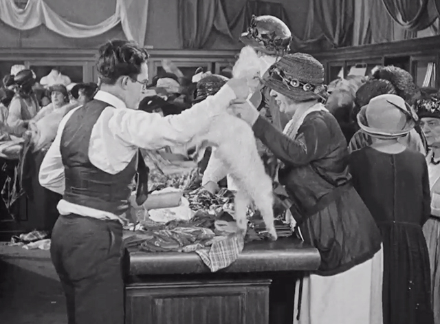 Safety Last! - Harold Lloyd handing longhair white cat by the tail to female customer