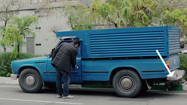 The Salesman - Emad Etesami Shahab Hosseini checking truck on street with Bengal tabby cat beneath
