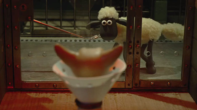 Shaun the Sheep Movie - Shaun the Sheep looking at cat inside glass cell