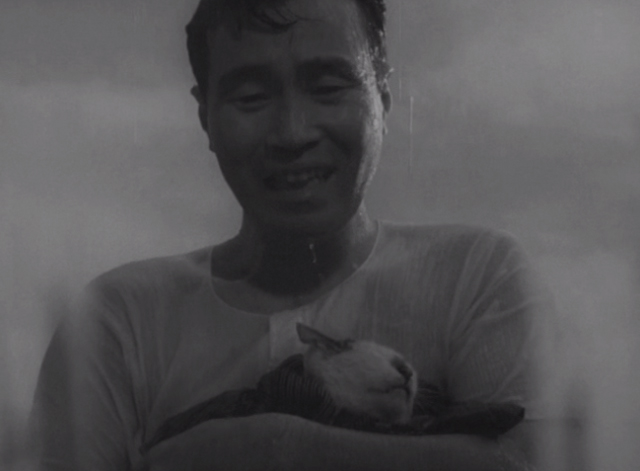 Shozo, a Cat and Two Women - Shozo Hisaya Morishige holding white and calico cat Lily in rain