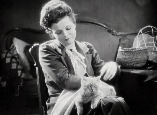 Silence - Norma Vera Reynolds knitting with tabby cat on lap