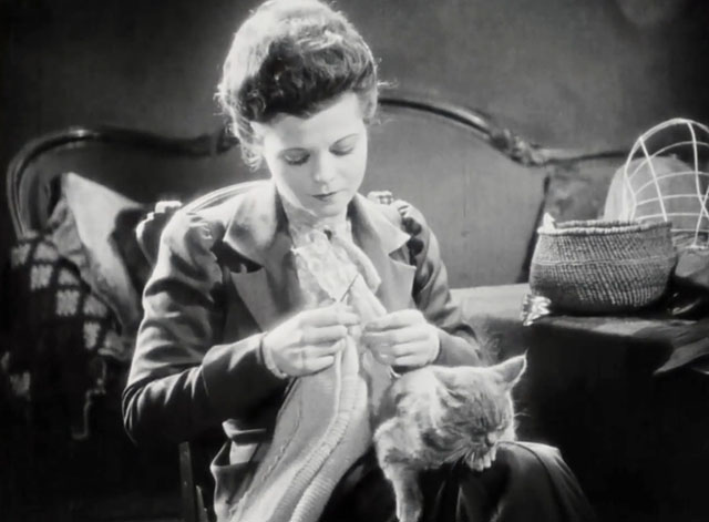 Silence - Norma Vera Reynolds knitting with tabby cat on lap