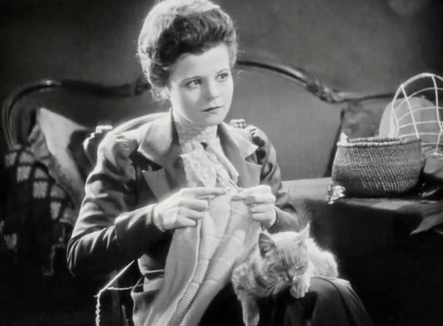 Silence - Norma Vera Reynolds knitting with tabby cat on lap