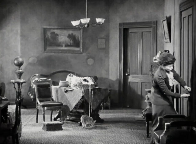 Silence - Norma Vera Reynolds answering door with tabby cat on floor behind