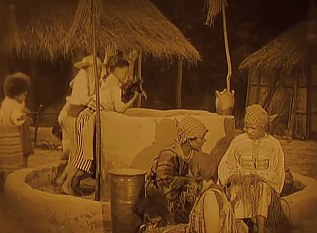 Siren of the Tropics - boys preparing to put tabby cat into well