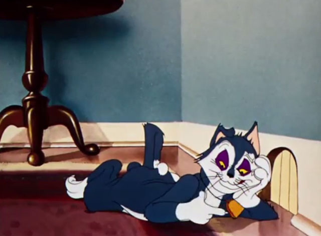 Sniffles Bell the Cat - blue and white cartoon cat lying on floor with black eyes and playing with bell on neck