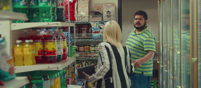 Someone Great - bodega man Dan Kenneth De Abrew being handed money by Claire Brittany Snow with tabby cat on rack behind
