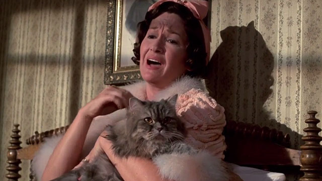 Something Wicked This Way Comes - Mrs. Nightshade Diane Ladd holding grey longhair tabby cat in bed