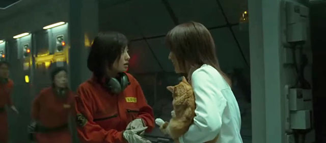 Space Battleship Yamato - Dr. Sado Reiko Takashima holding ginger and white tabby cat while talking to female crew member