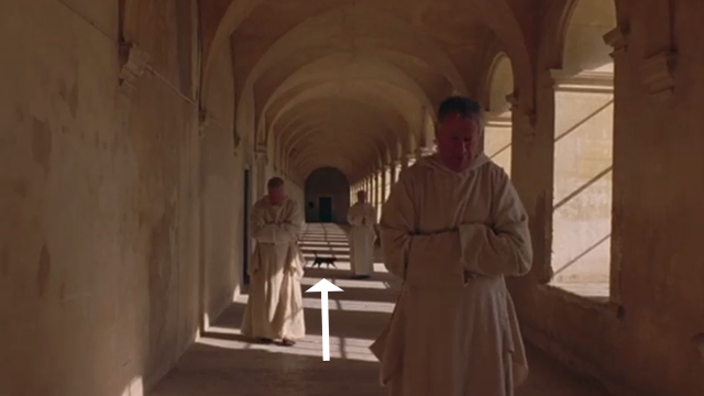 The Statement - black cat walking behind monks