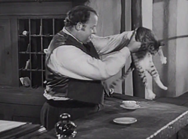 Station West - hotel clerk Burl Ives picking up tabby cat from counter