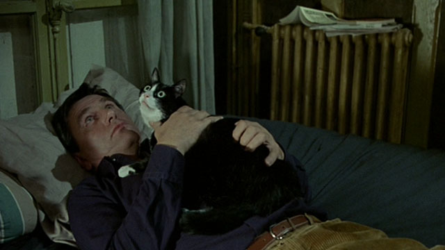 Histoire de Marie et Julien - The Story of Marie and Julien - Jerzy Radziwilowicz lying on bed with tuxedo cat Nevermore Gaspard