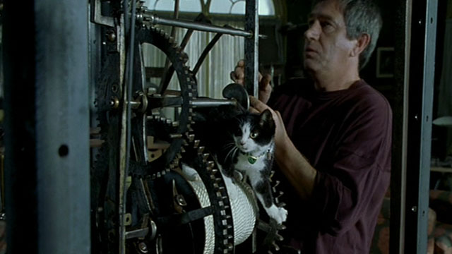 Histoire de Marie et Julien - The Story of Marie and Julien - Jerzy Radziwilowicz with tuxedo cat Nevermore Gaspard on clock