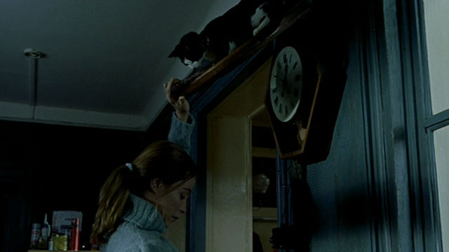 Histoire de Marie et Julien - The Story of Marie and Julien - Emmanuelle Béart with tuxedo cat Nevermore Gaspard on top of clock
