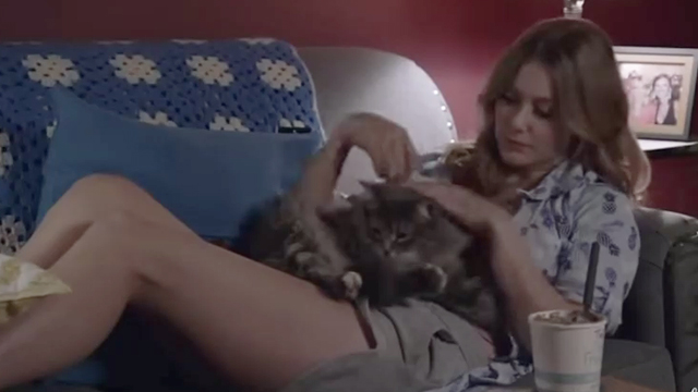 Summer in the City - Taylor Julianna Guill lying on couch with long haired gray tabby cat Oscar on lap